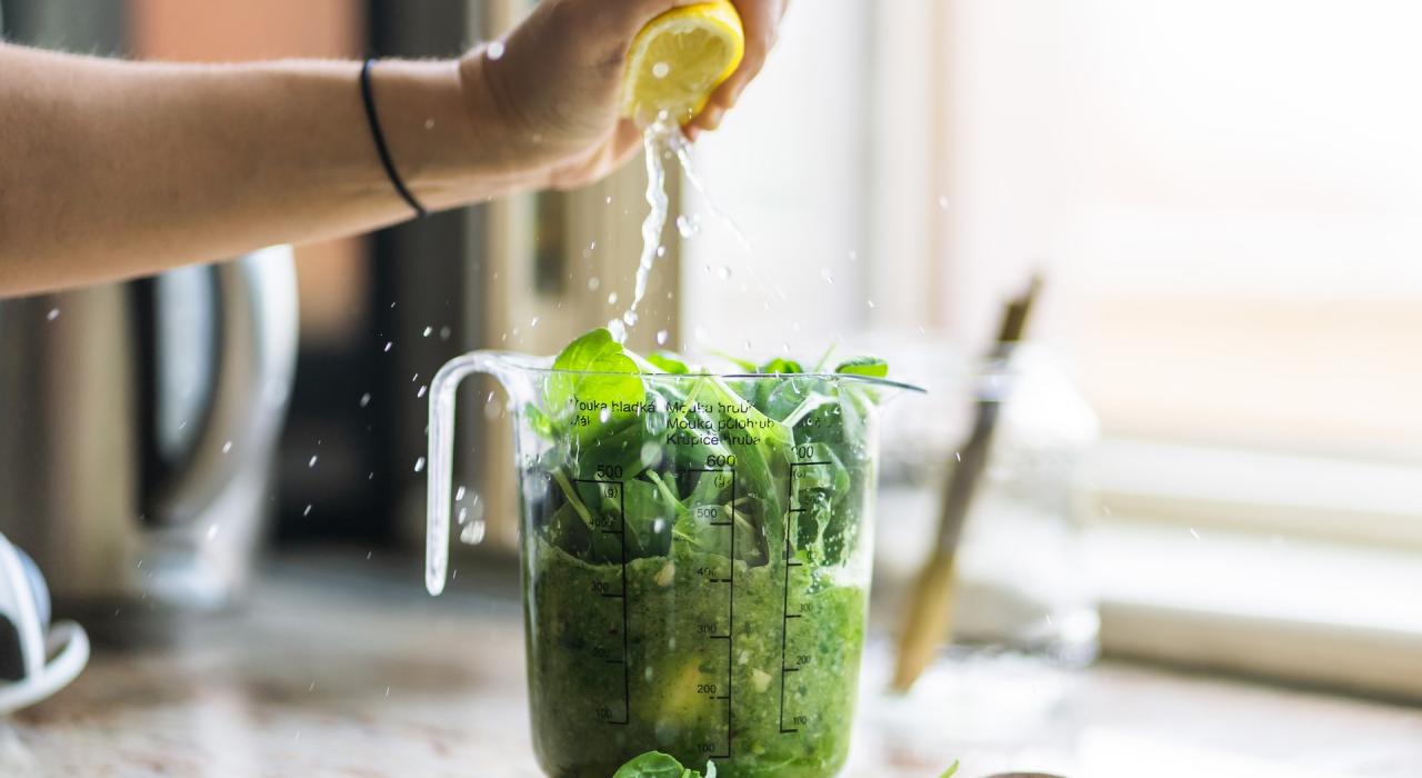 b07ae03c-849a-41ed-936d-83f4dff0f5a2 Frau macht frischen Pesto mit frisch gepresster Zitrone