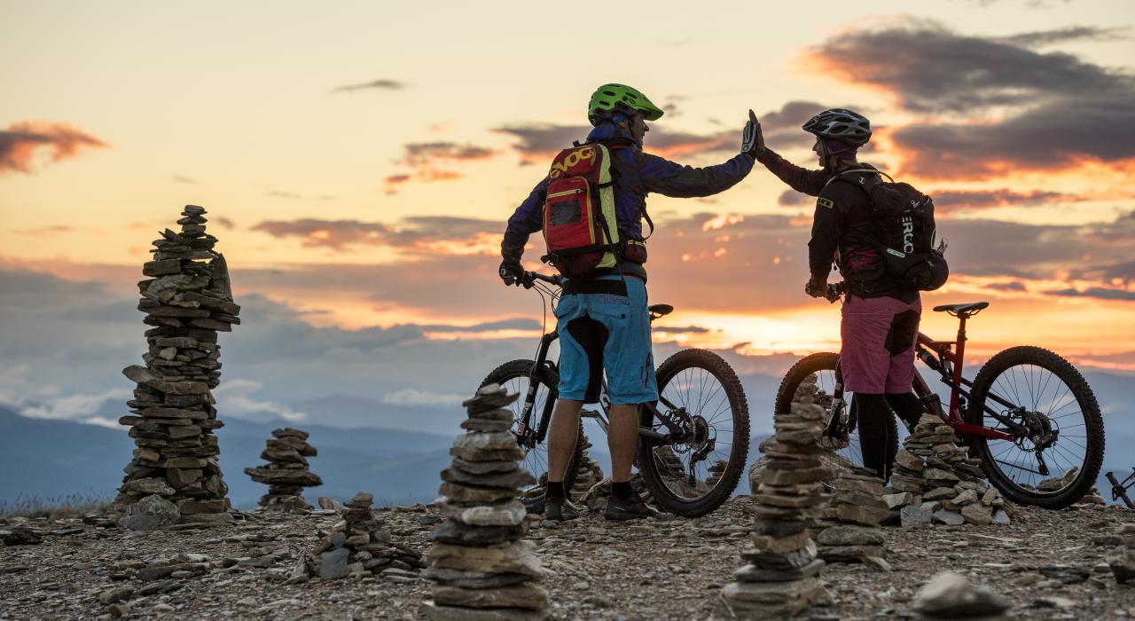 Zwei Personen, die beim Mountainbiken in Bad Kleinkirchheim auf dem Berg abklatschen