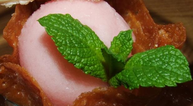 DSCF9962 Ein Dessert bestehend aus einer rosa Kugel in einer knusprigen Schale, dekoriert mit einem Minzblatt