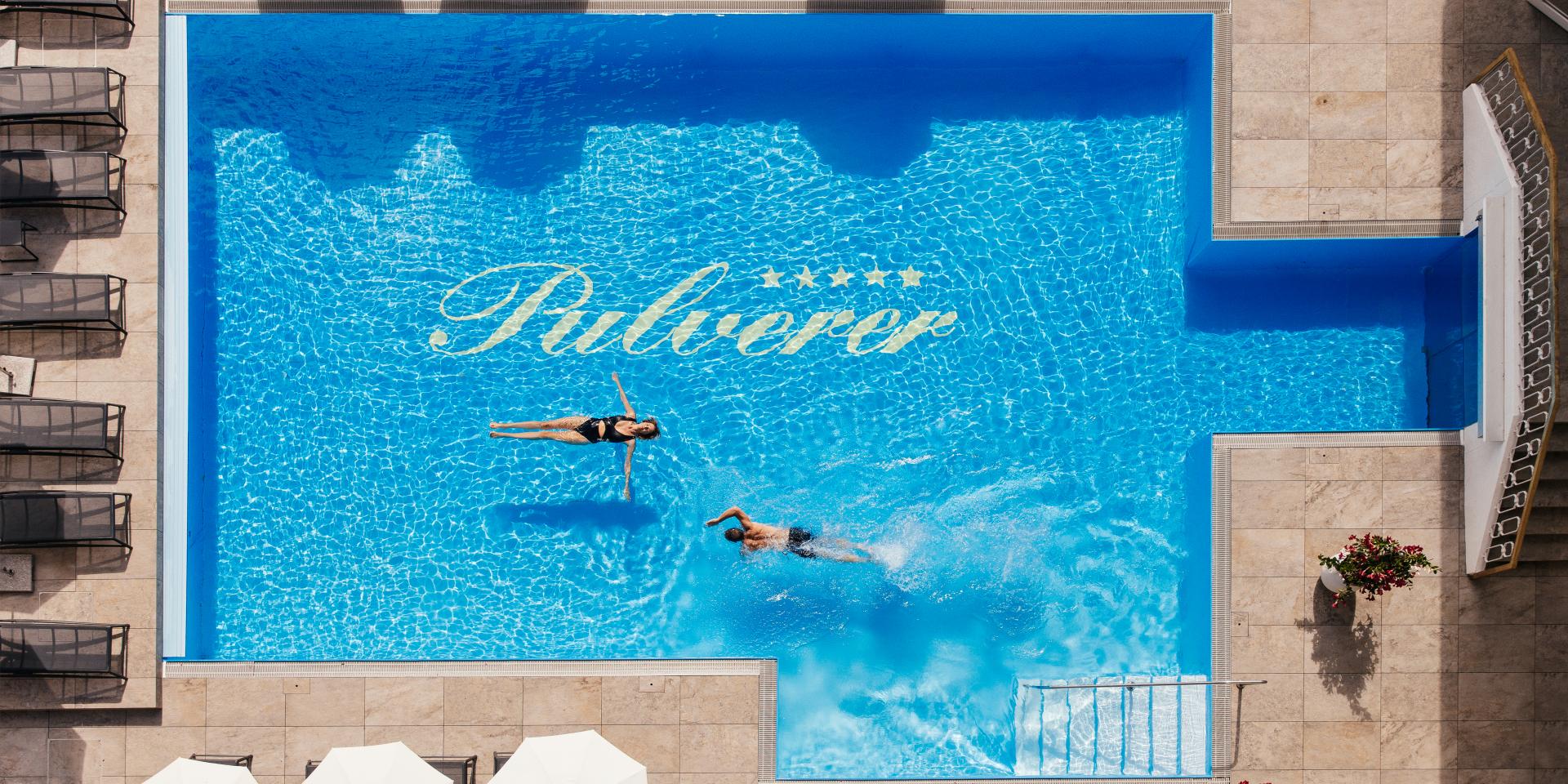 088A7544 Foto aus der Luft von zwei Personen, die im Außenpool im Thermenhotel in Kärnten schwimmen