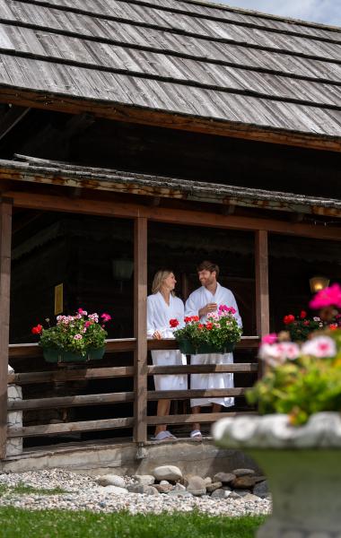 Pulverer_23_CJB-078 Ein Mann und eine Frau in Bademänteln unterhalten sich auf der Terrasse des 5-Sterne-Hotels in Bad Kleinkirchheim