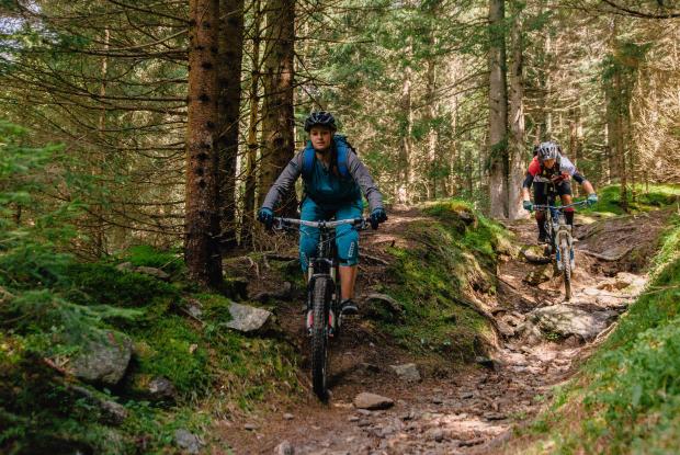 Radfahren_nock_bike_Bike Trail_Bad Kleinkirchheim_Sommer © Mathias Prägant_MBN Tourismus Frau und Mann fahren einen Trail im Wald auf einem Fahrrad