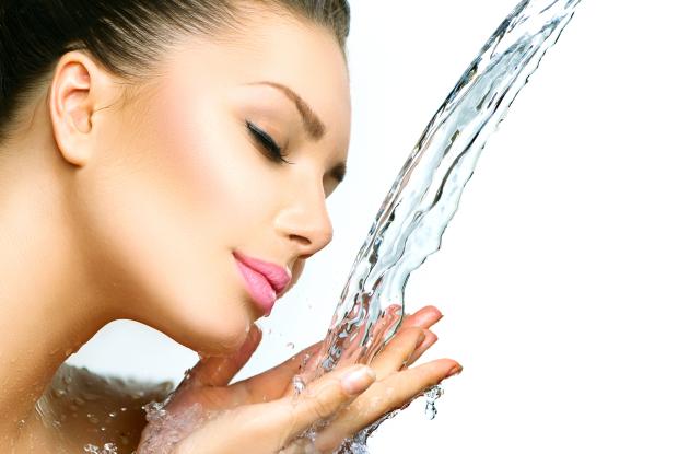 01_wellness_shutterstock_192143633 Eine Frau, die ihr Gesicht mit frischem Wasser wäscht, mit geschlossenen Augen