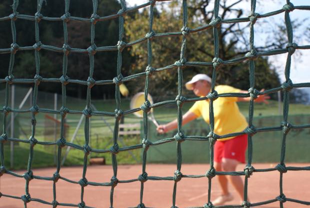 DSC02351 Nahaufnahme eines Tennisspielers mit Fokus auf das grüne Netz